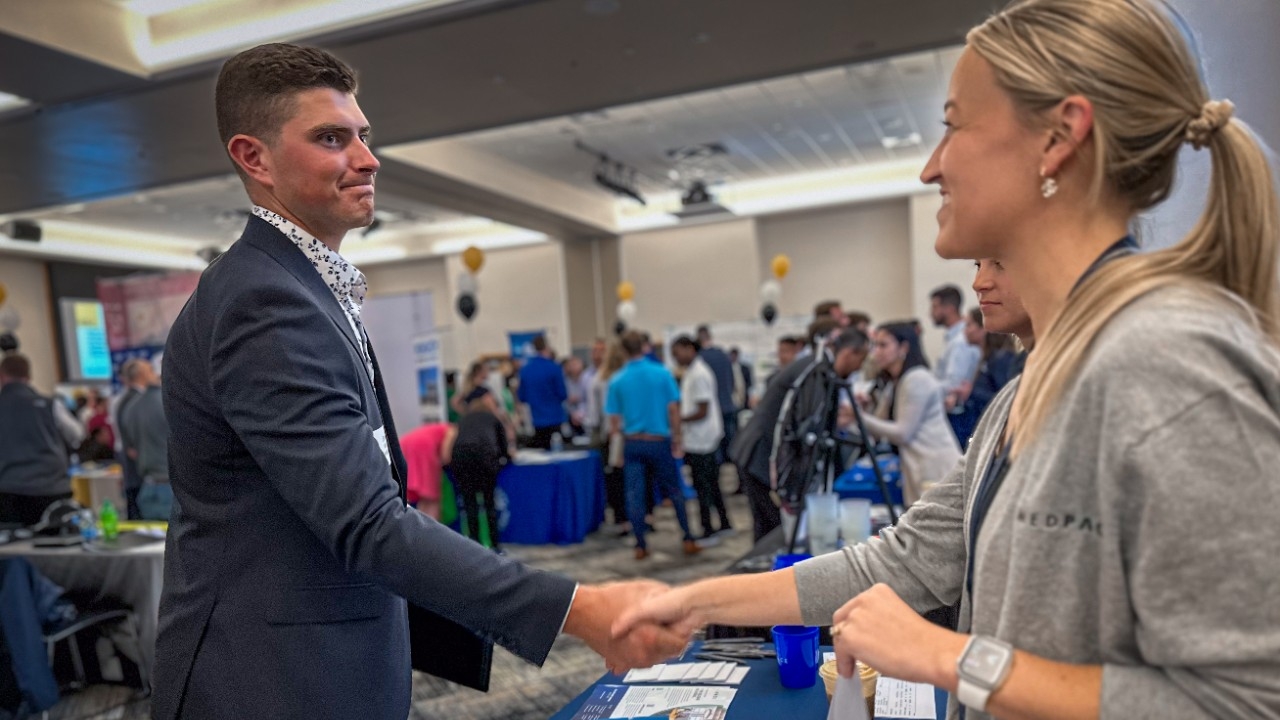 Student in business suit shaking hands