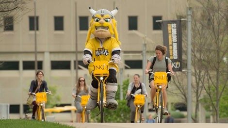 Victor and students riding bikes on campus
