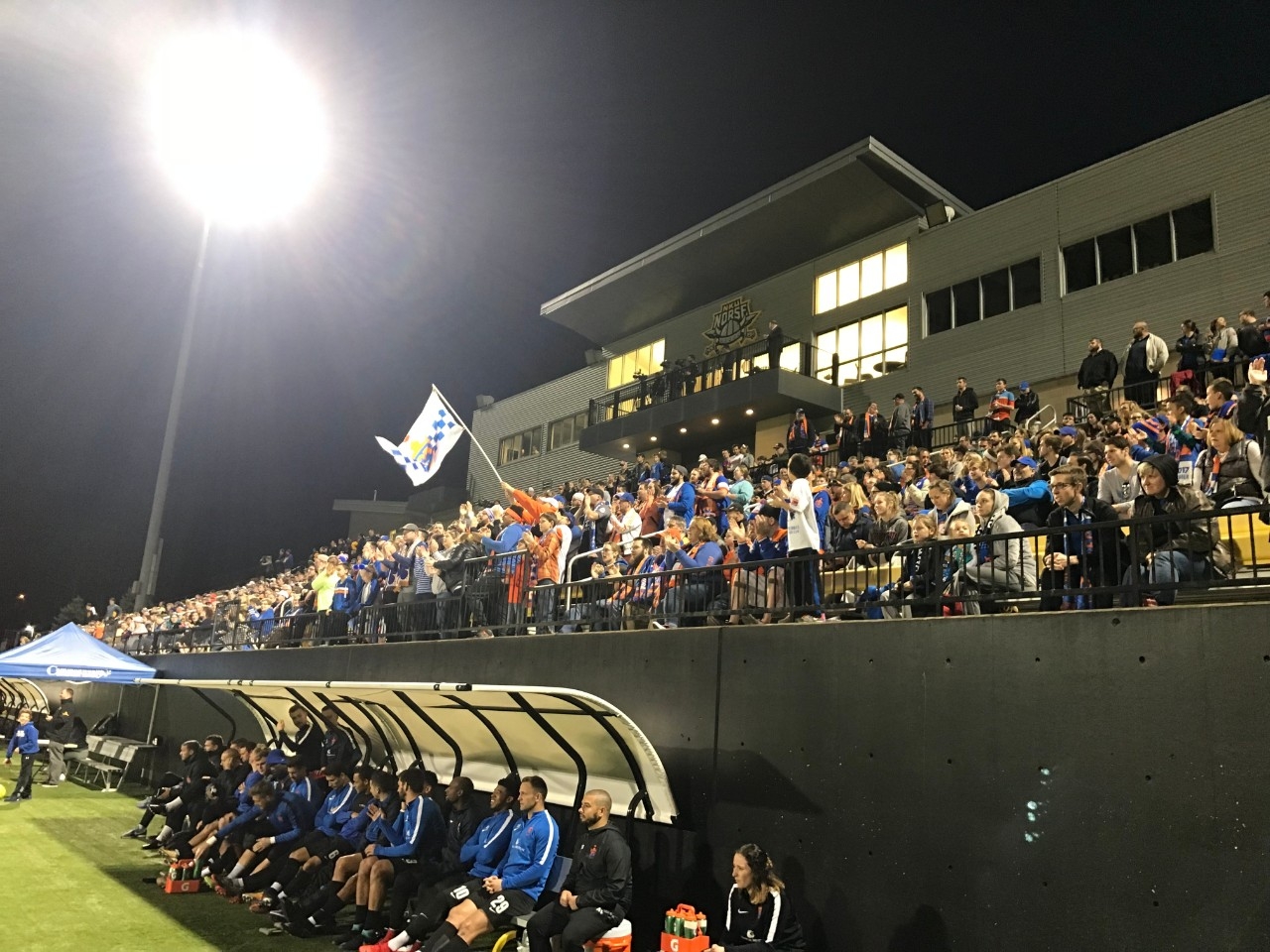 Crowds of students cheer at FC Cinnnati 2 match at night.