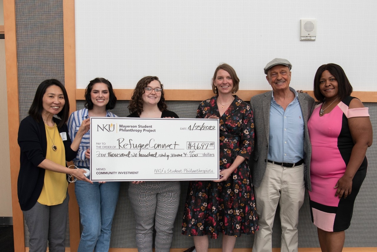 Students holding a large check from donor.