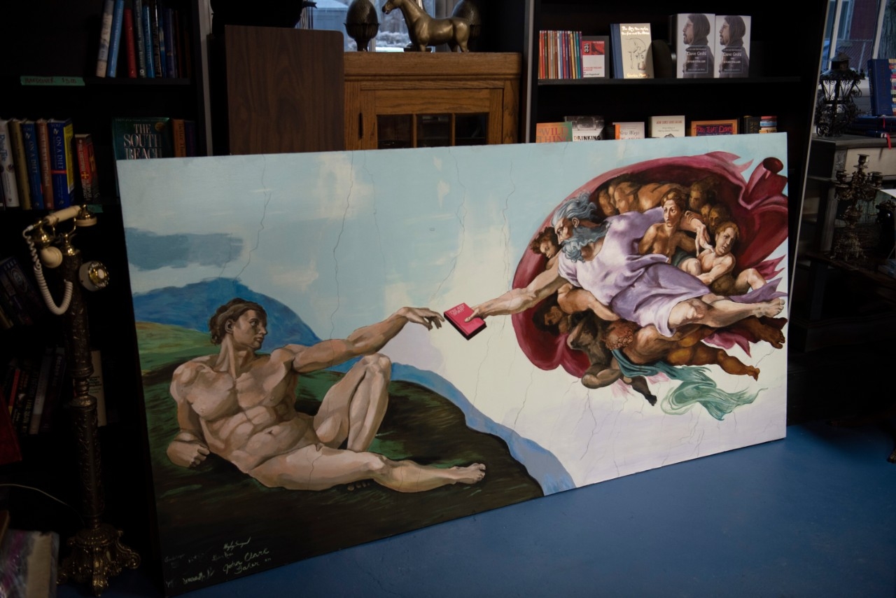 Mural that resembles the painting "The Creation of Adam", with God instead holding a book.