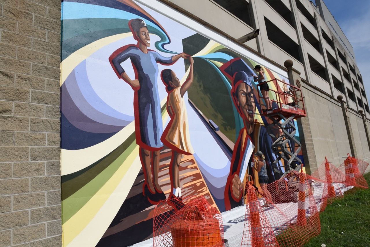 Painters working on wall mural.