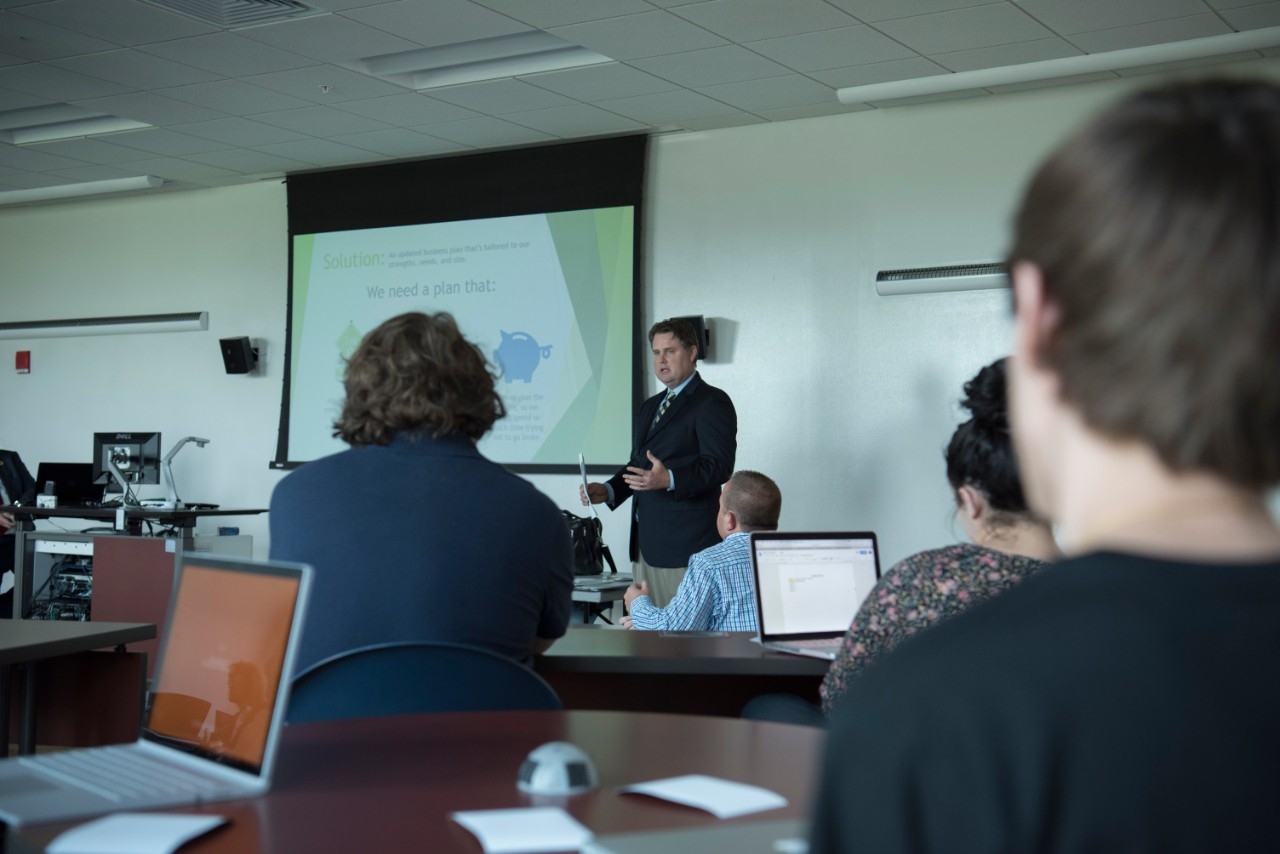 Person giving a presentation inside classroom.