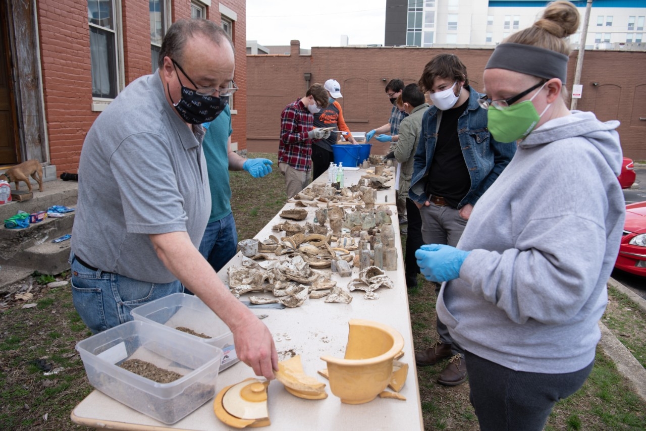 Line of volunteers working outdoors on excavation project.