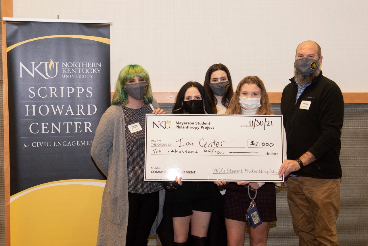 Group posing with large donors check.