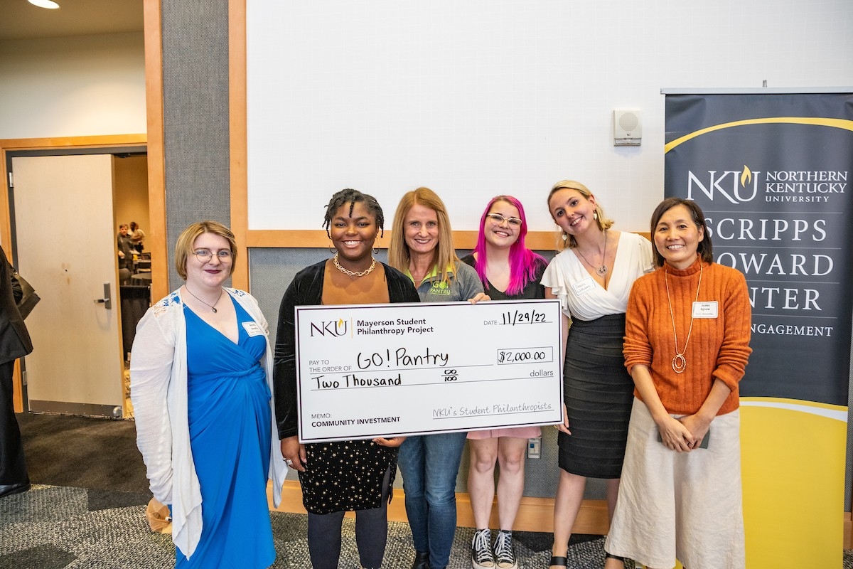 Group posing with presentation check.