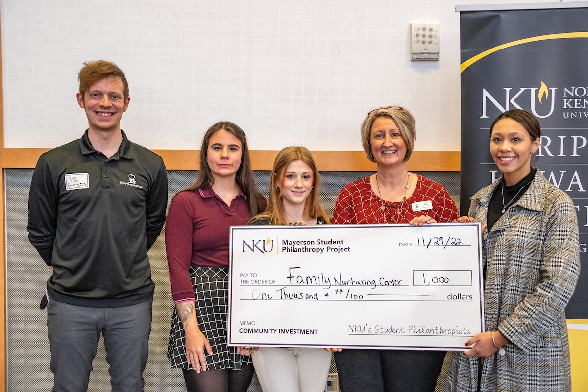 Class posing with a presentation check.