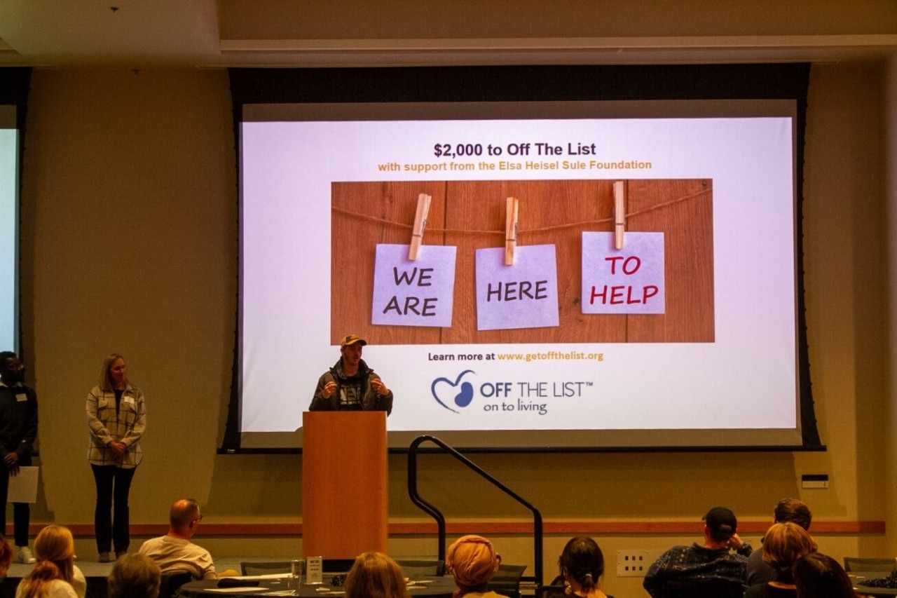 A student presents an award to the nonprofit Off The List.