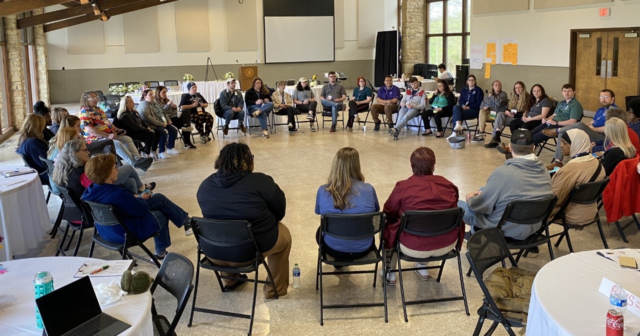 Group of community members sitting in chairs in a circle.