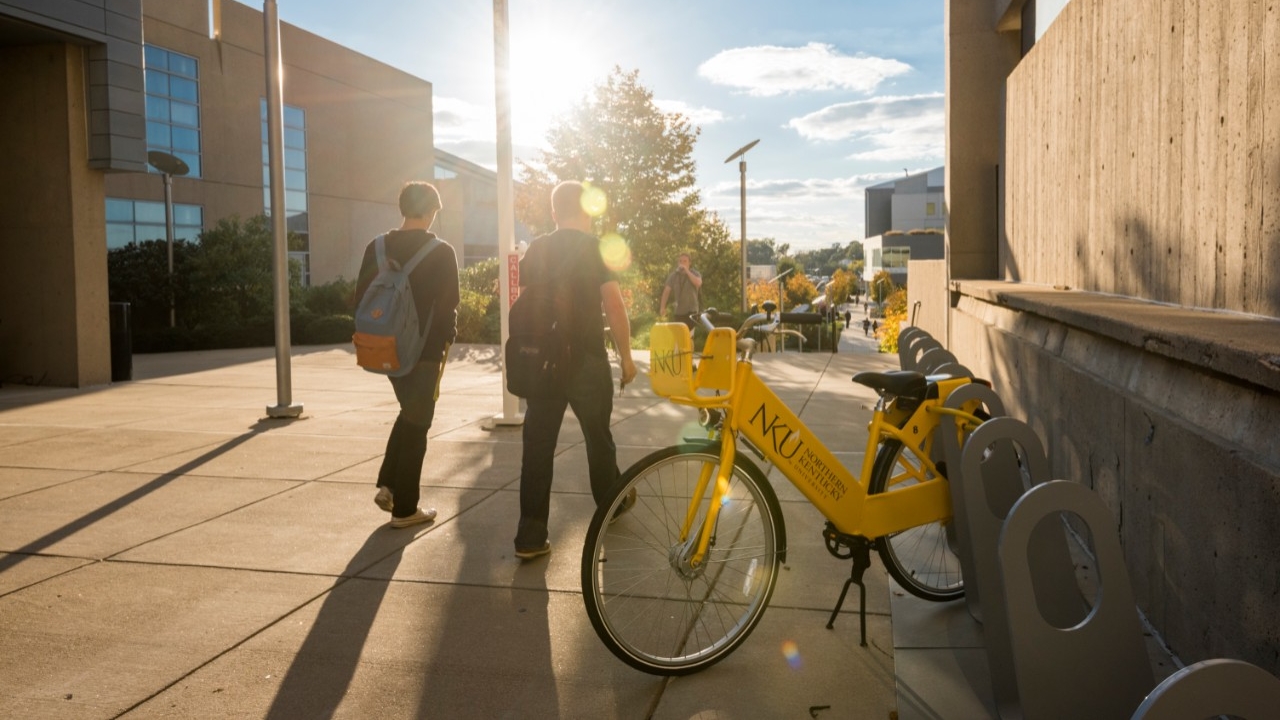 Students walk by a collection of bikes available for free on-campus travel
