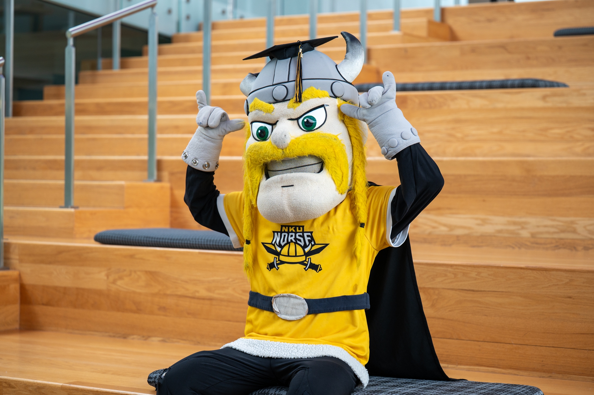 Victor Viking sitting on bleachers
