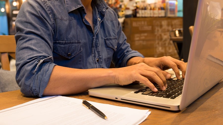 A student typing on a laptop computer