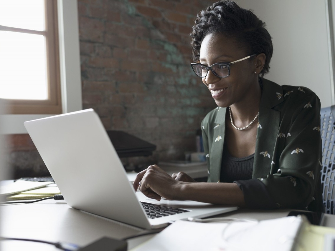 A woman typing on a laptop computer