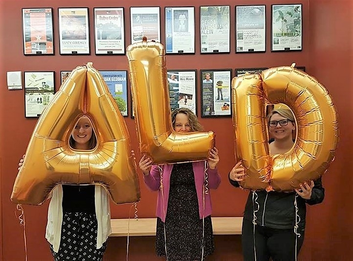 Three students holding three balloons, which spells out "ALD" together.