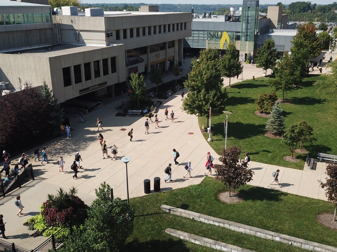 Aerial view of NKu's campus during the daytime, overlooking students walking to the Student Union and University Center.
