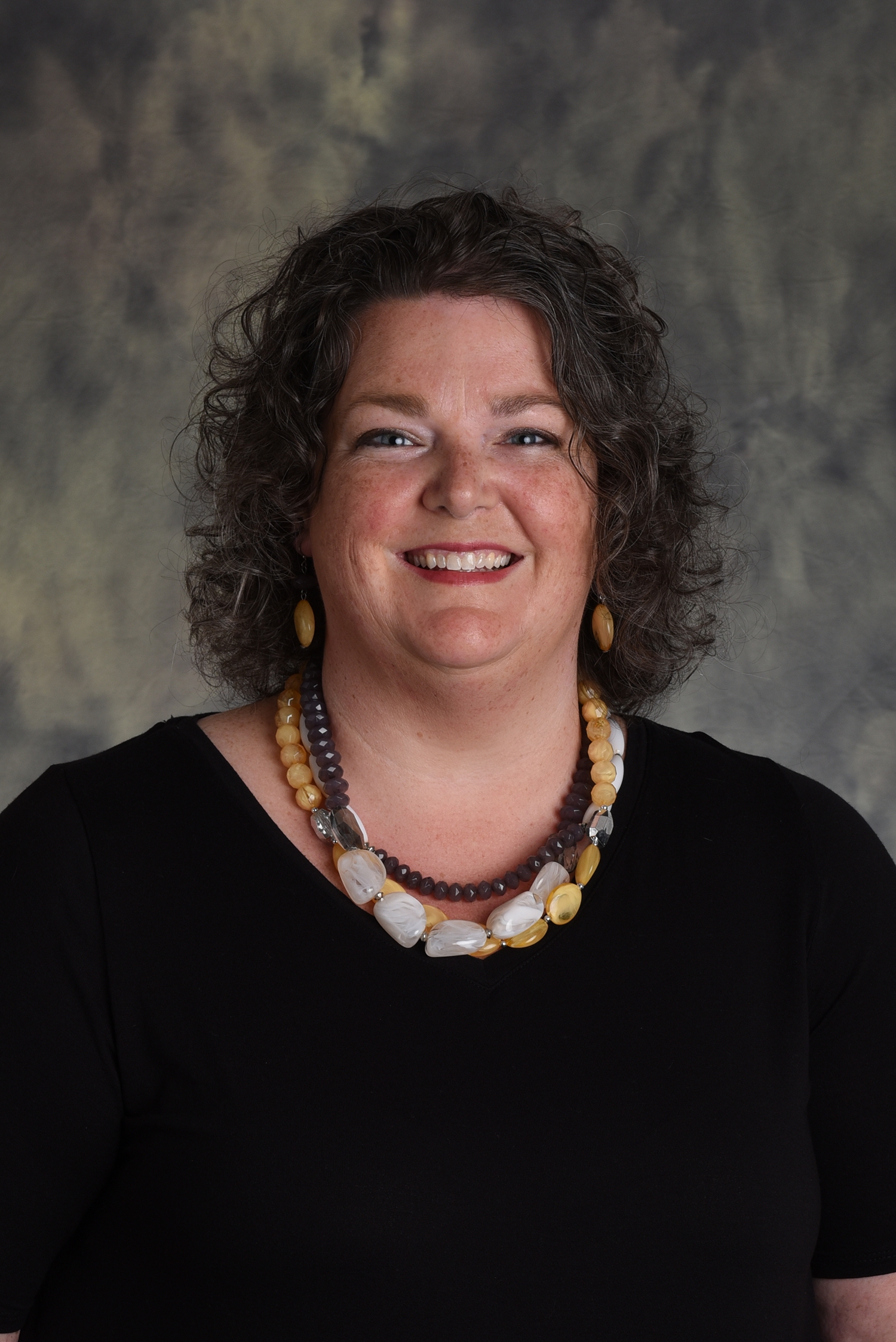 Photo of a dark curly haired middle aged woman