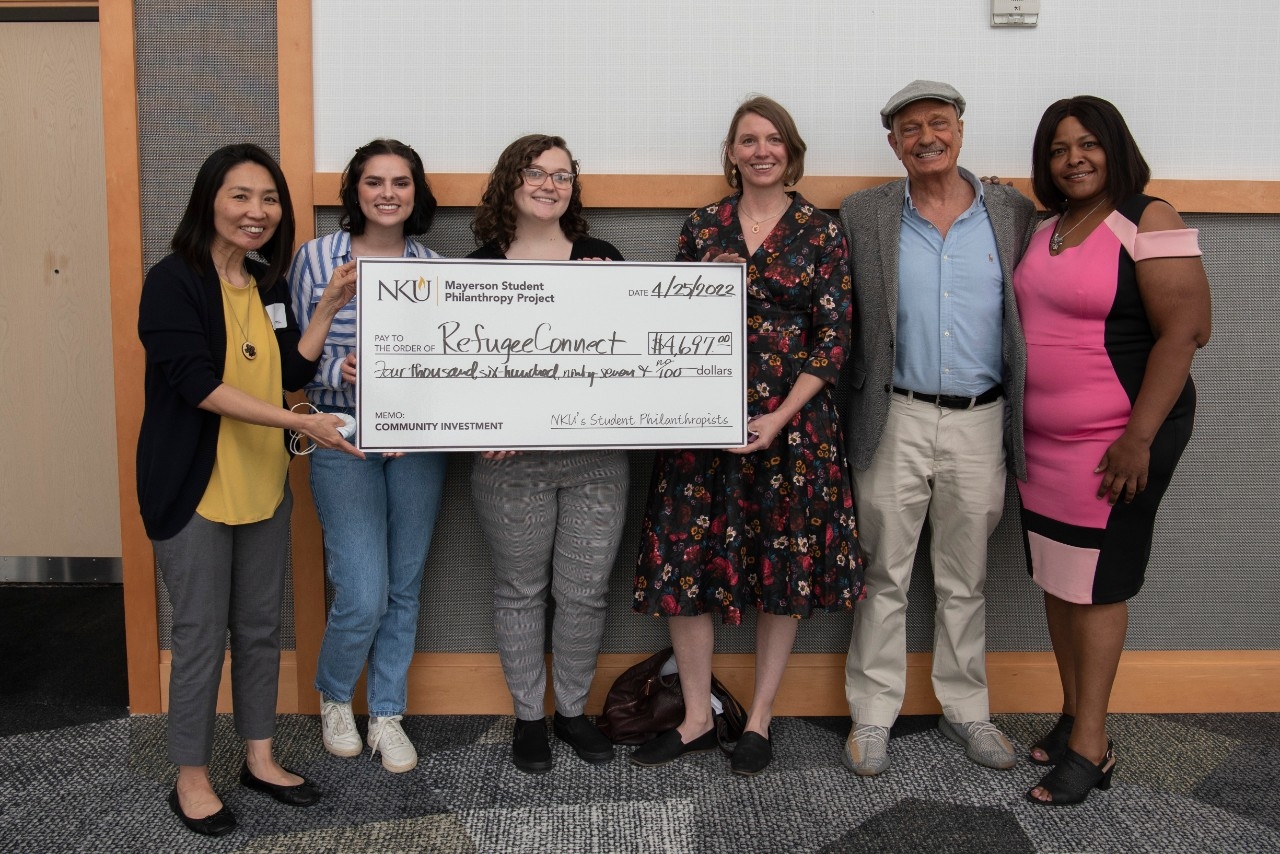 Students presenting a check to community members