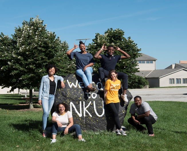Students posing at NKU Rock sitting outside of Norse Commons