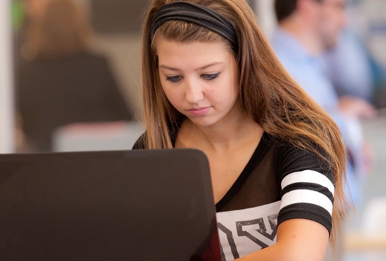 An NKU student working on her laptop.