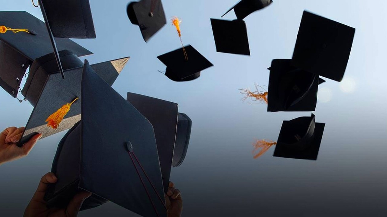 Graduation image showing mortarboards being thrown into the air.