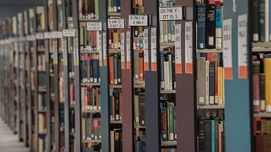Steely Library interiors, shelving with lots of books, signs and endcap colors.