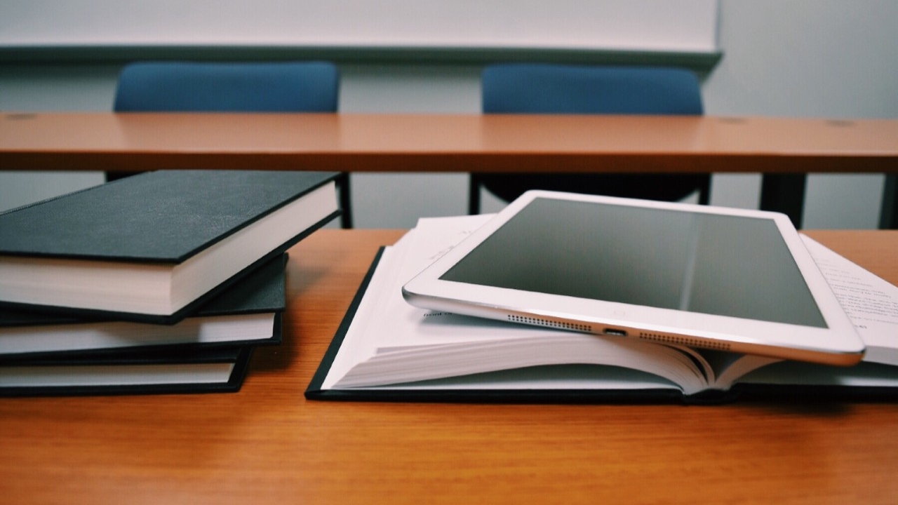 Books and tablet on a desk.