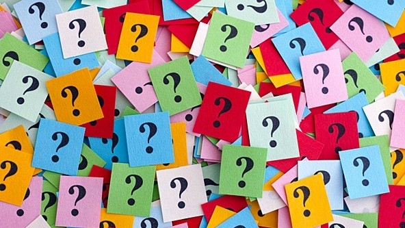 Background full of colorful print cards with black question marks.