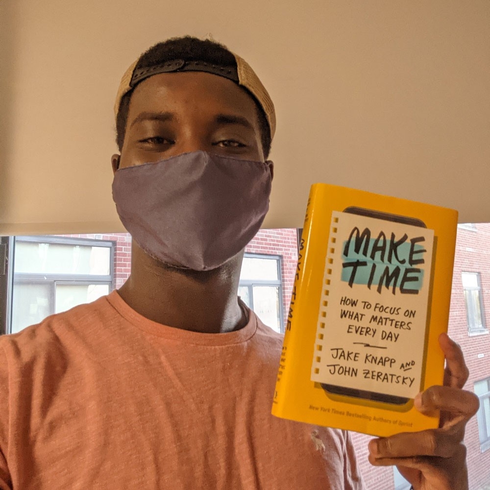 Guy Georges Adou Bogolo poses with their favorite book, "Make Time, How To Focus on What Matters Every Day" by Jake Knapp and John Zeratsky