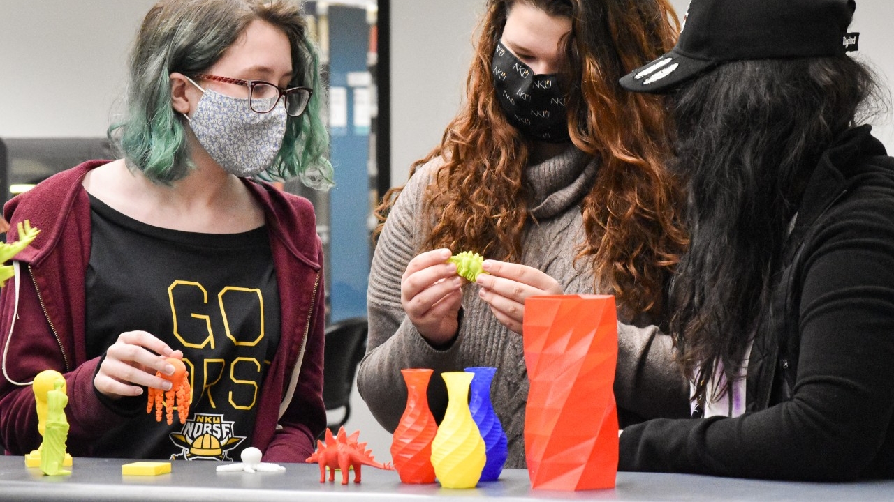 2022 BOSS members holding and investigating 3D printed objects in Steely's makerspace, Stego Studio. 
