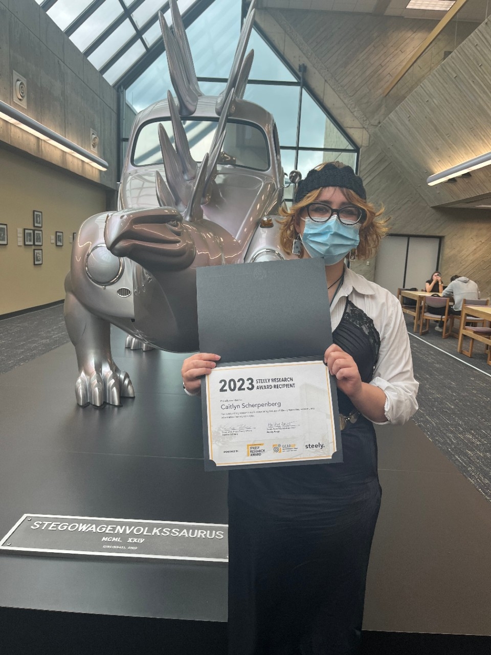 Caitlyn Scherpenberg poses with the Steely Research Award certificate.