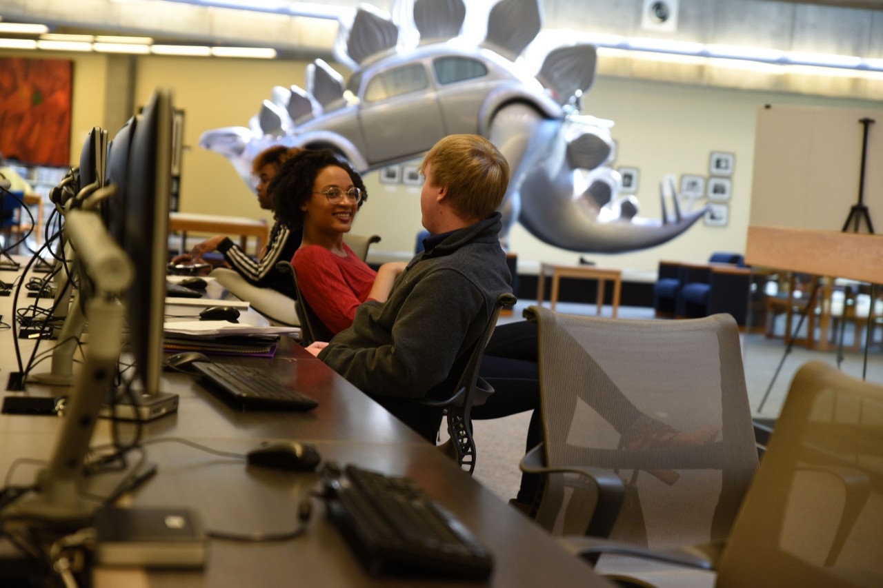Student sitting at a table working on a laptop