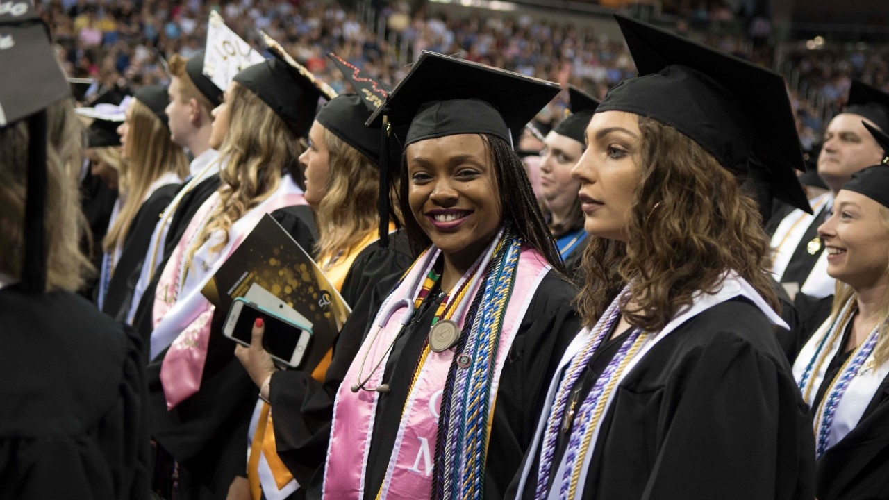 Graduate holding diploma