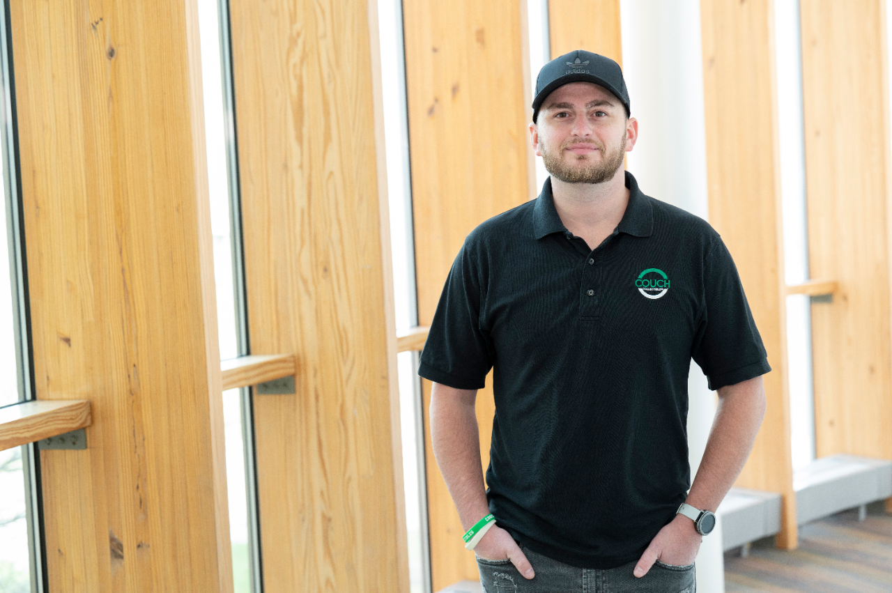 Justin Couch stands in front of large windows at Grifin Hall.