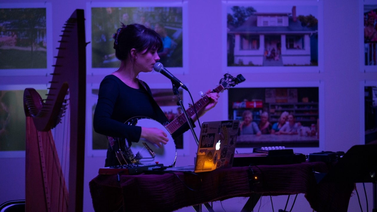 Bailey Miller performs under blue light in the SOTA gallery
