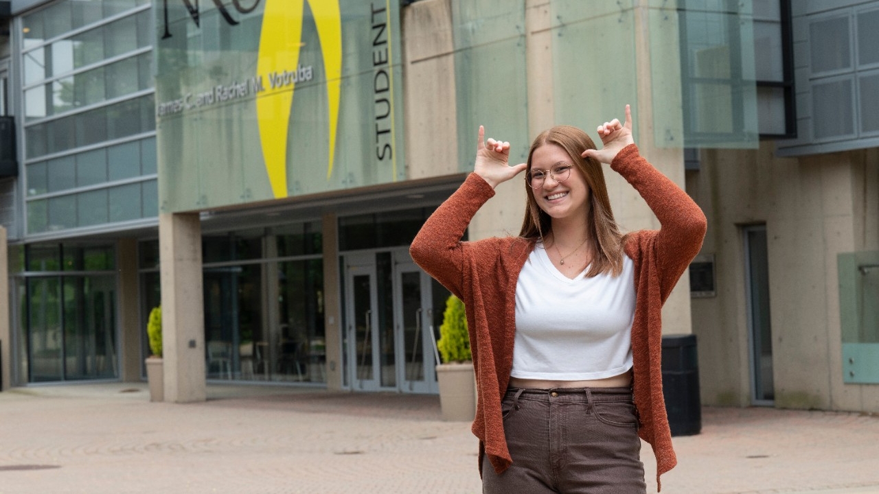  Jessi Spradlin gives the Norse Up hand sign outside of the Student Union