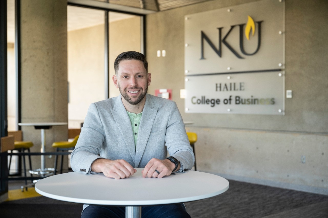 Zac Strobl sits as a desk in the NKU College of Business lobby.