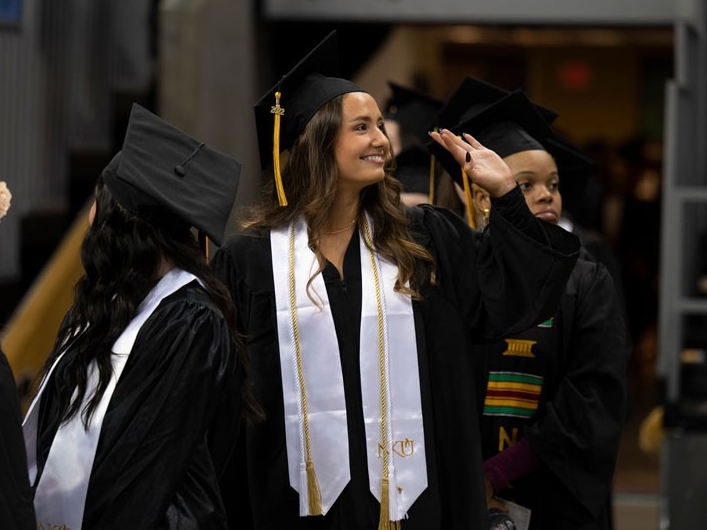 Graduate waving at Commencement