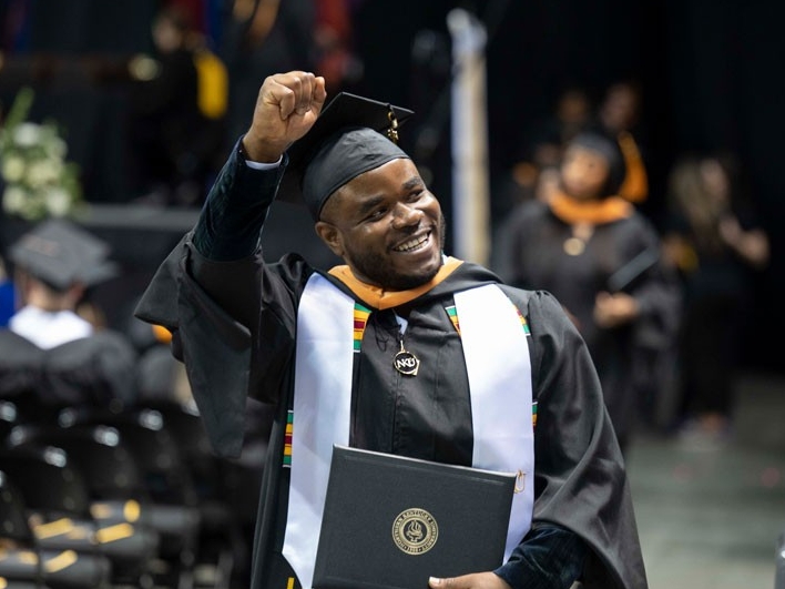graduate waving at family