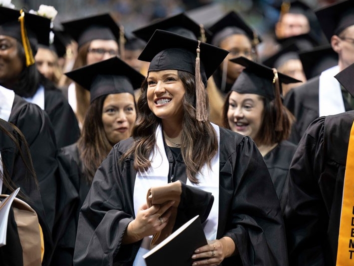 graduates standing at commencement