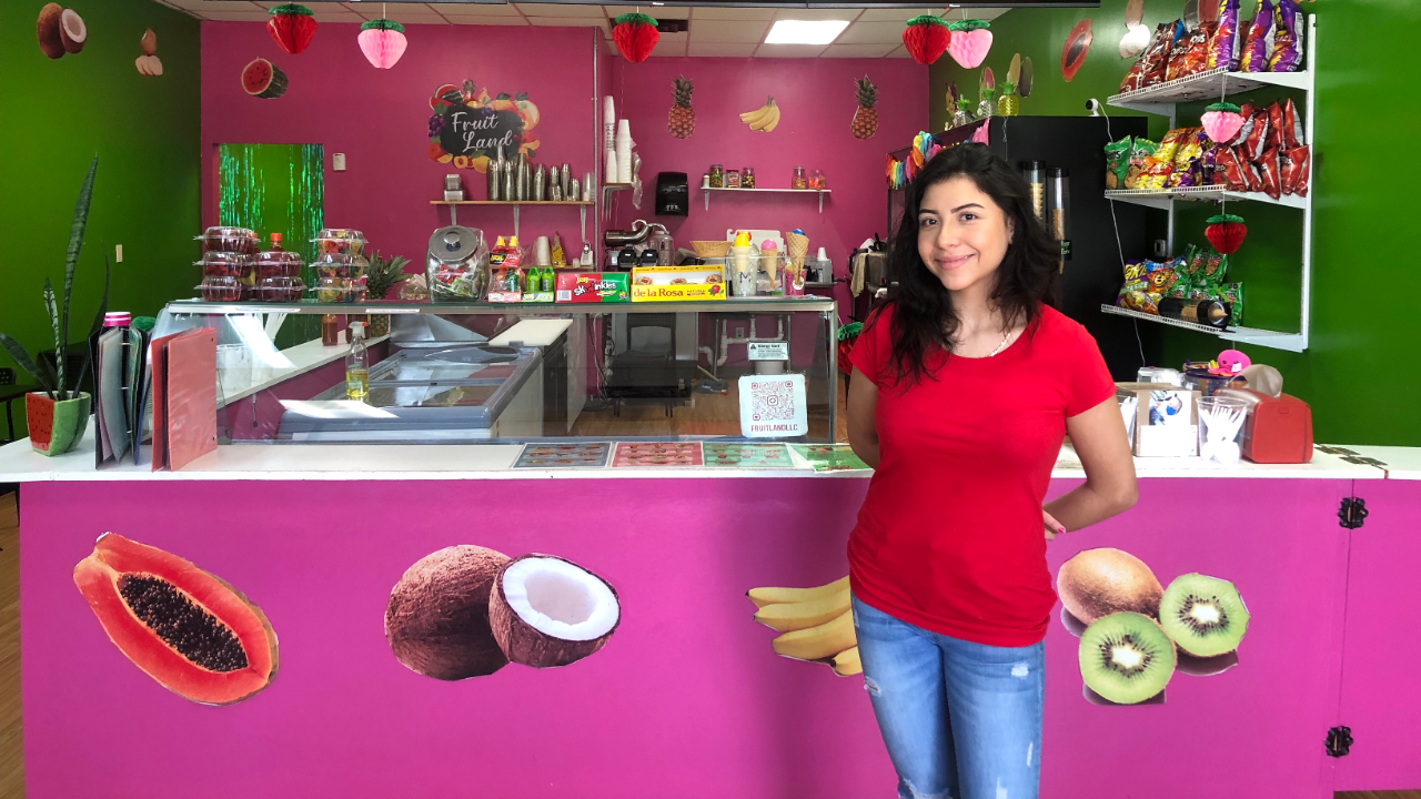  Paloma stands in front of Fruit Land's counter.
