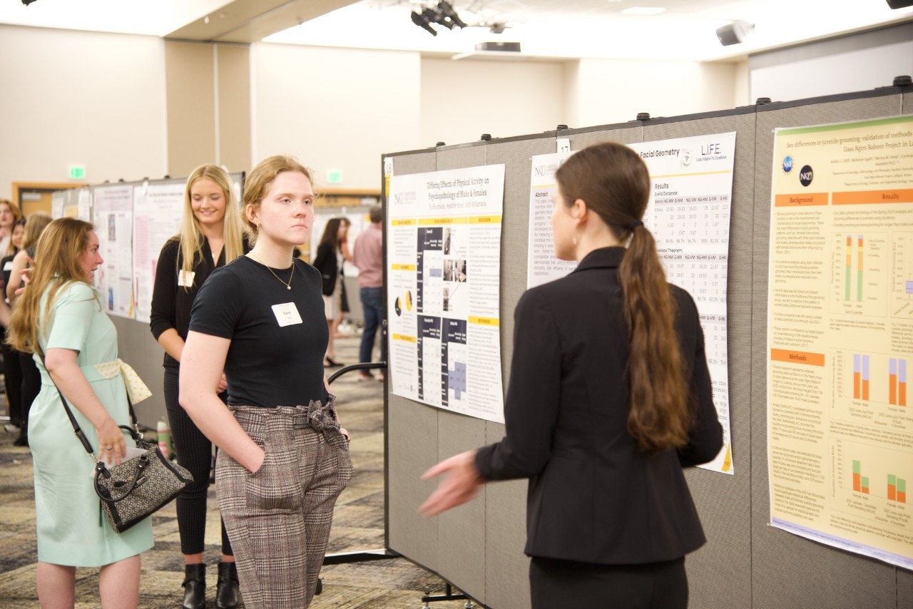 Students discuss their poster presentations