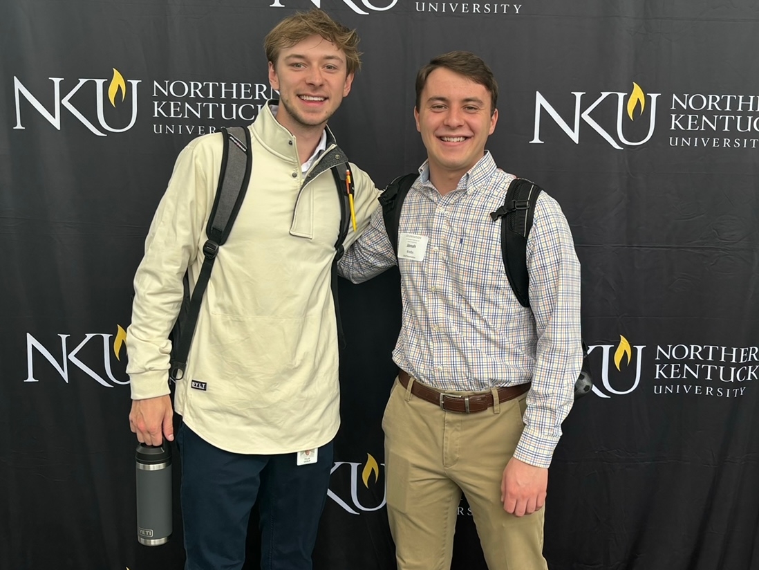 Jonah and Tyler in front of backdrop