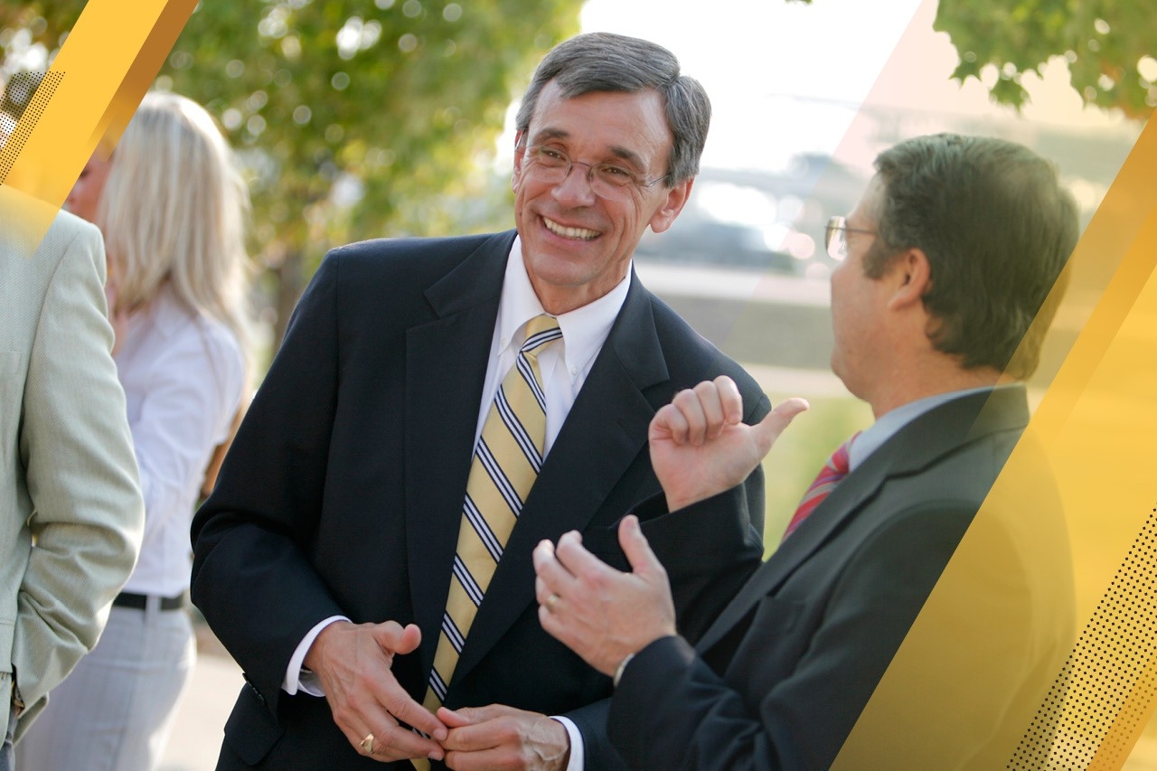 President Emeritus James Votruba smiling as he walks outdoors