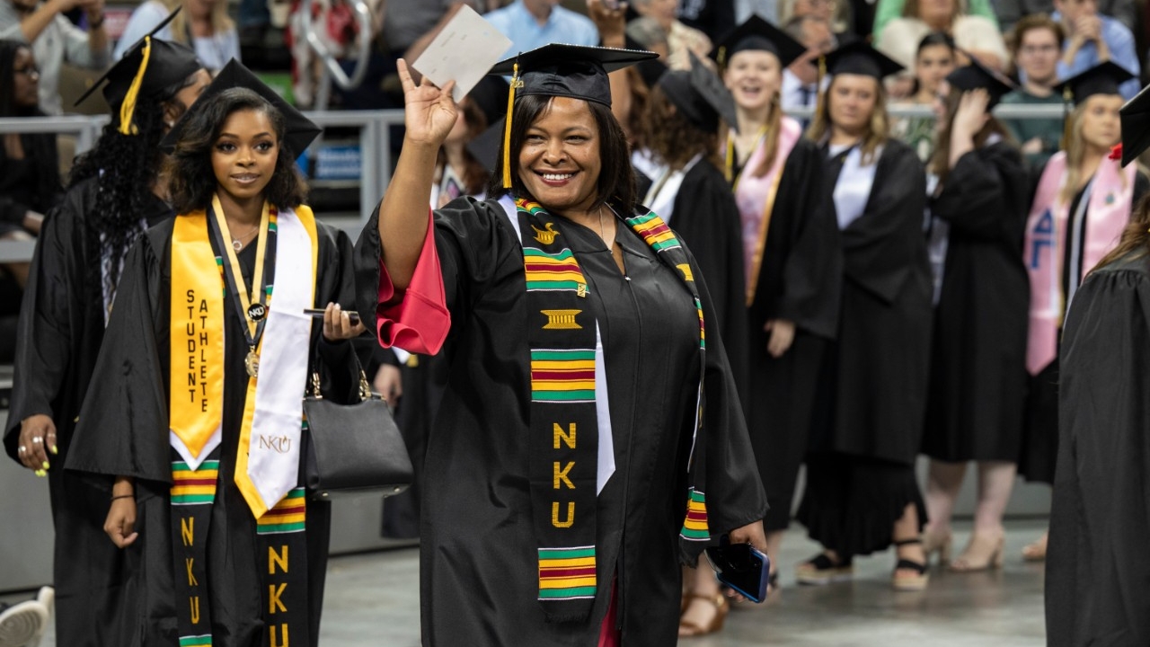 Graduating adult student walking during commencement