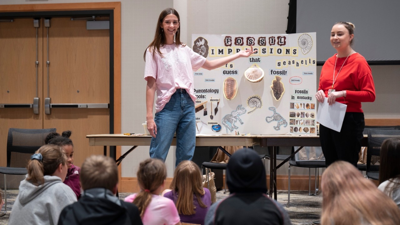 Two students giving a science lesson to P-12 children