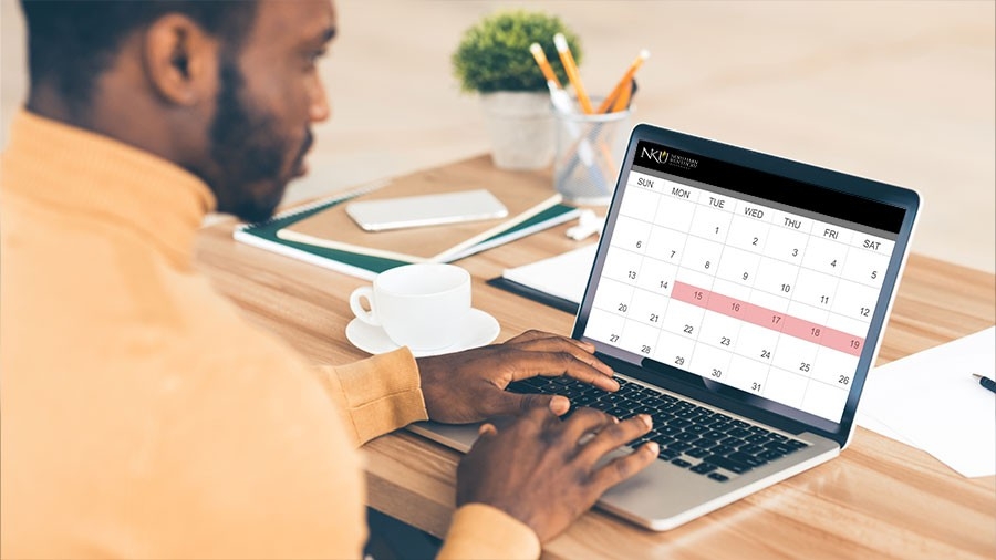 A student looking at a calendar on a laptop