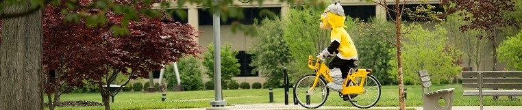 Viktor Viking riding bicycle through campus.