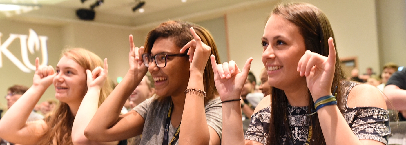 Three students give the "Norse Up" salute.