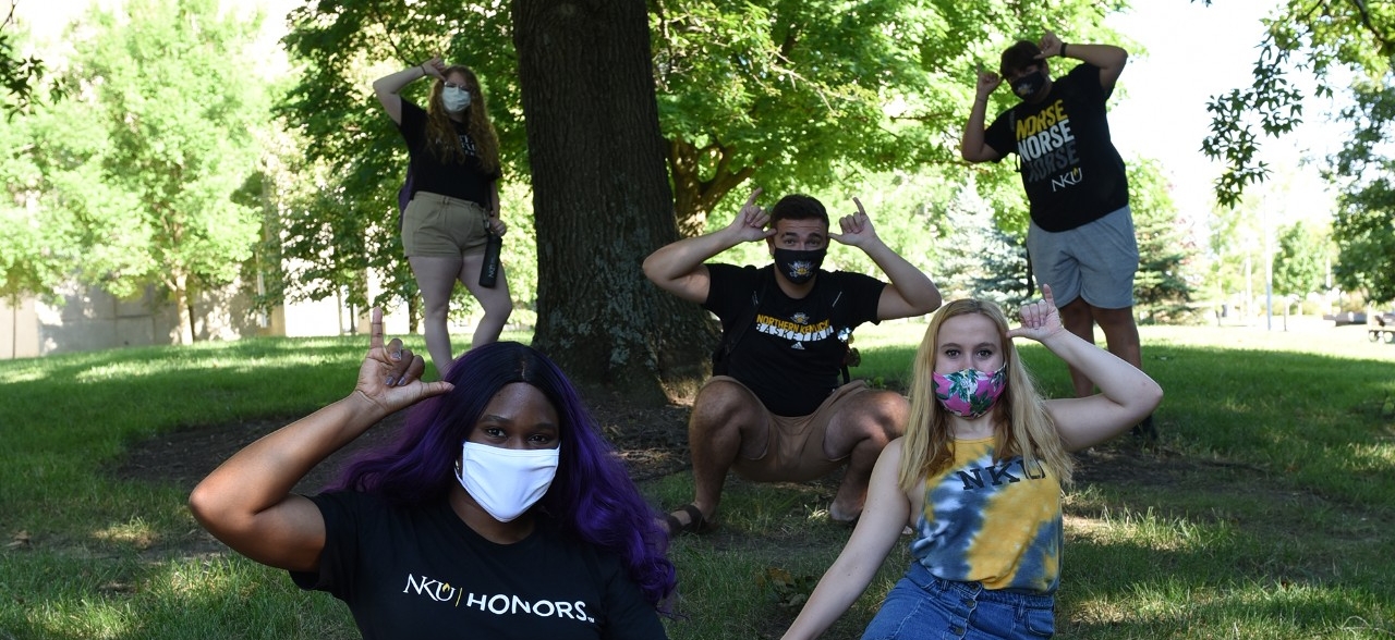 NKU students wearing Norse gear and facial coverings on campus.