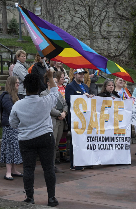 LaVette Burnette waving the LGBTQ Progress Pride Flag at event